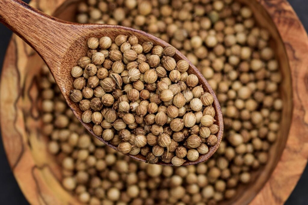 Mastering the First Impression: Your intriguing post title goes here Detailed view of coriander seeds in a wooden spoon, emphasizing texture.
