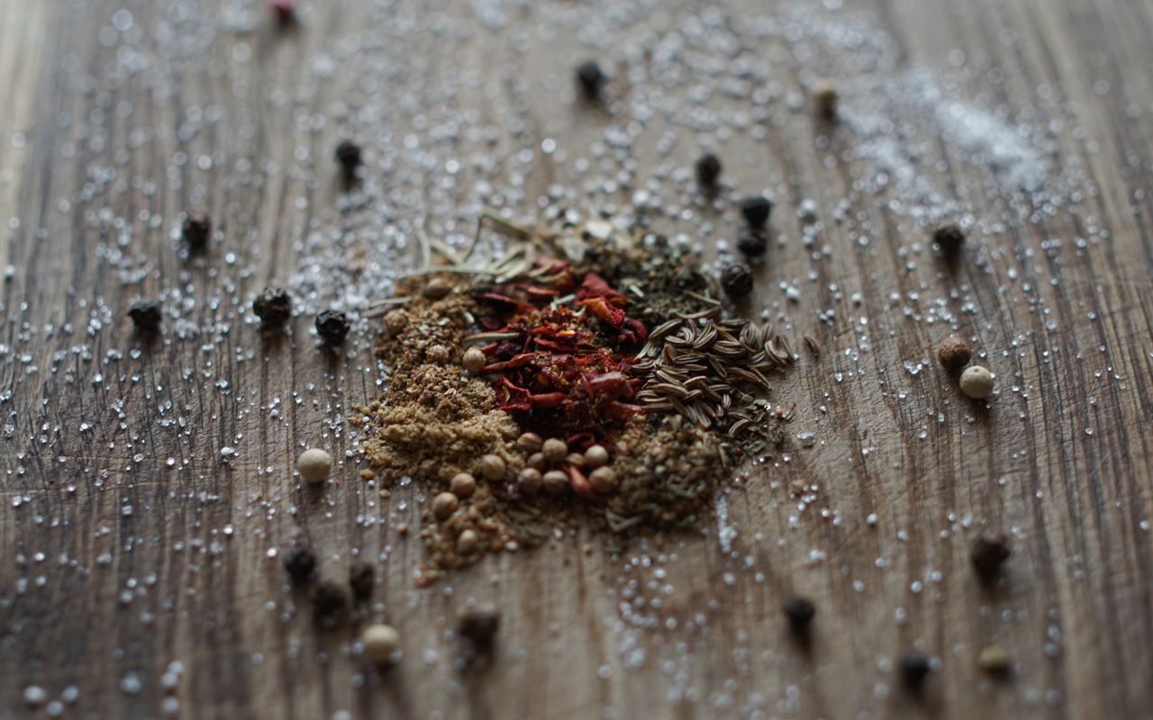 services-02 A selection of mixed spices and salt on a rustic wooden background.