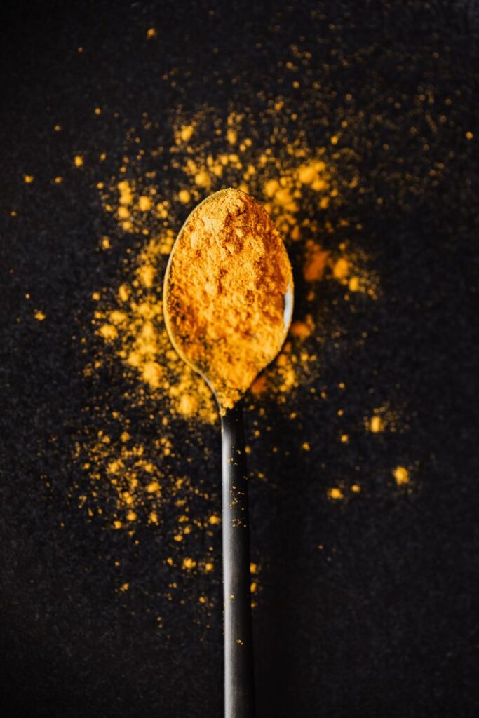 Crafting Captivating Headlines: Your awesome post title goes here From above of creative composition of bright ground turmeric on metal tablespoon spilled on black table