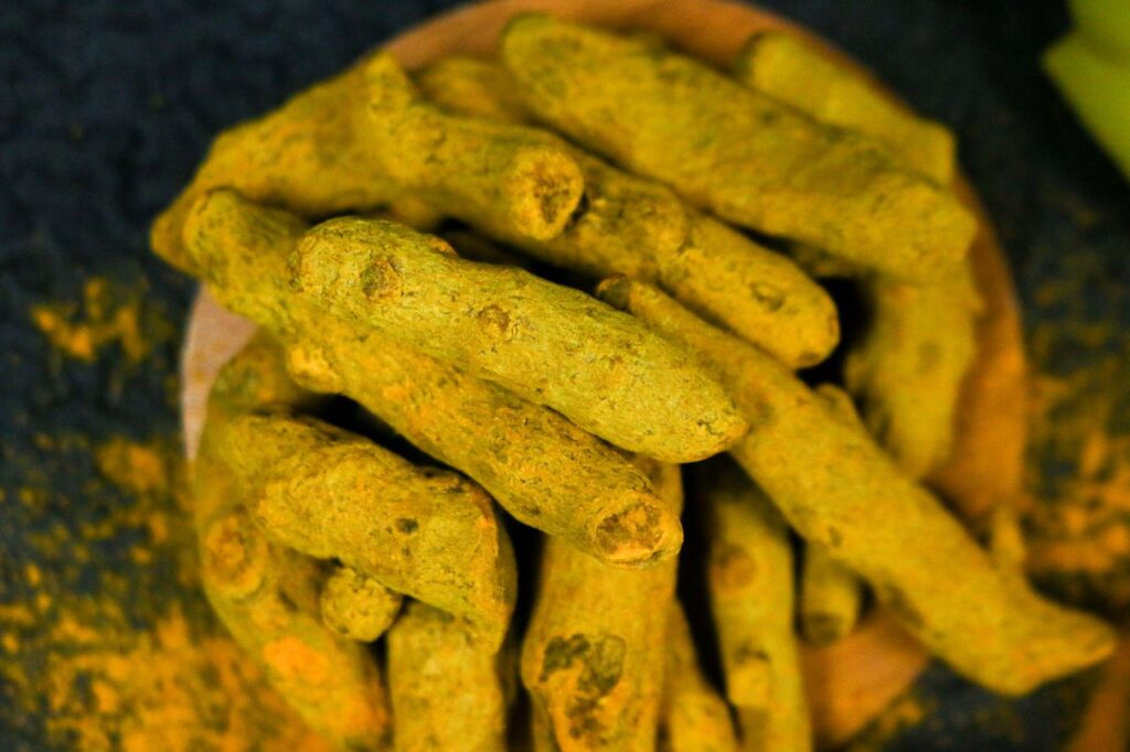 The Art of Drawing Readers In: Your attractive post title goes here Vibrant close-up of organic turmeric roots displayed on a wooden plate, perfect for cooking and health inspiration.